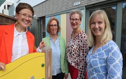 Vor der Kita stehen Pfarrerin Nora Göbel (Gemeindepfarrerin in der Ev. Dietrich-Bonhoeffer-Kirchengemeinde), Claudia Meinert (Leitung der Ev. Kindertageseinrichtung Wellensiek-Grünewaldstraße), Christiane Prenneis (Abteilung Bau & Projektentwicklung des Verbands der Evangelischen Kirchenkreise Bielefeld-Güterloh-Halle-Paderborn, Zuständigkeiten Instandhaltung Kiten), Melanie Hoffmann (Geschäftsführerin und Leitung des Referats Tageseinrichtungen für Kinder im Ev. Kirchenkreis Bielefeld).